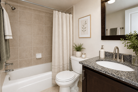 A bathroom with a white toilet, a white bathtub, a sink, and a mirror.