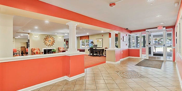 A hallway with a red wall and a white column at Rainier Manor Apartments, Mount Rainier, MD