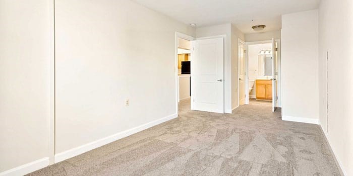 A room with a carpeted floor and a white door. at Rainier Manor Apartments, Mount Rainier, MD, 20712