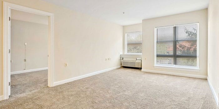 A spacious room with a window and a bench. at Rainier Manor Apartments, Mount Rainier