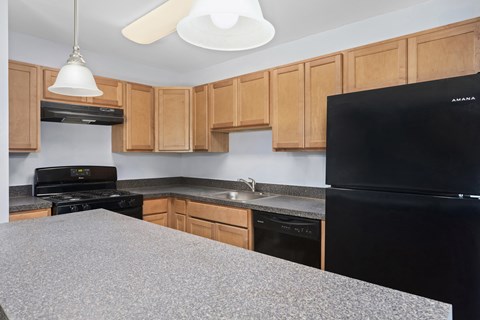 A kitchen with wooden cabinets and black appliances.