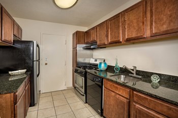 kitchen at Cole Spring Plaza apartments in downtown Silver Spring MD with stainless steel appliances and dark wood cabinets - Photo Gallery 6