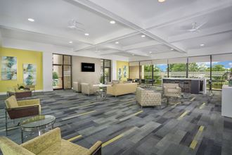 community space with gray carpeting and light green lounge chairs  at Seven Springs Apartments, College Park, MD - Photo Gallery 2