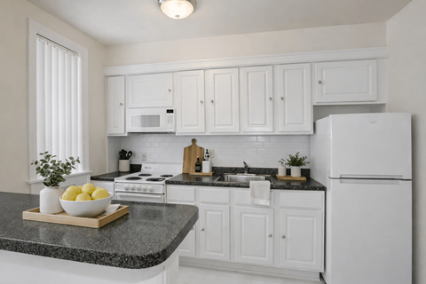 A kitchen with white cabinets and appliances.