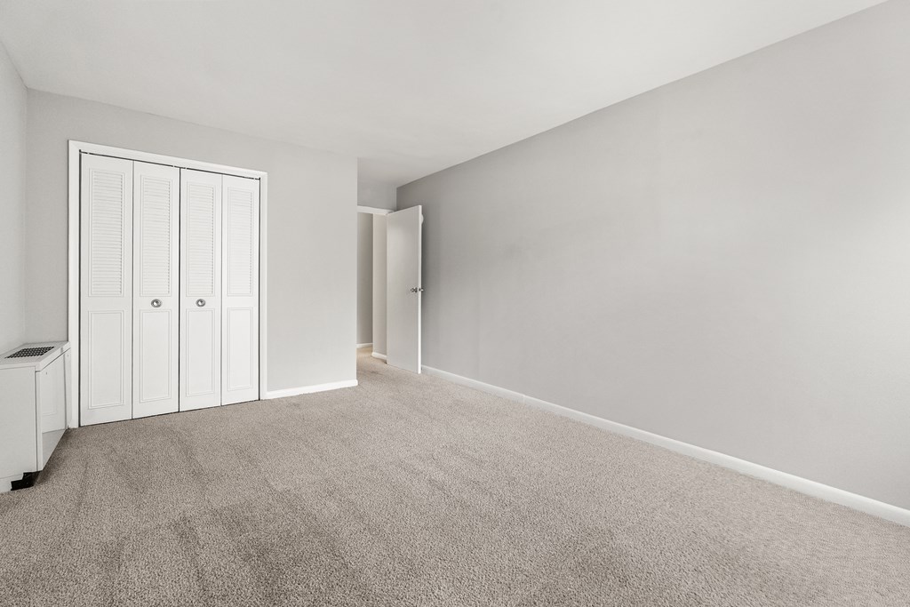A room with a carpeted floor and white walls.