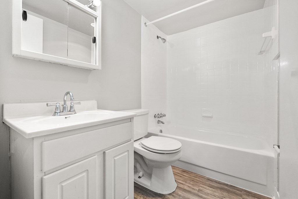 A white bathroom with a toilet, sink, and bathtub.