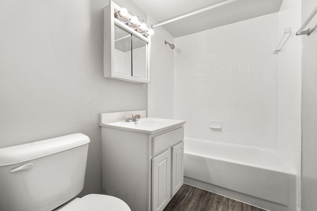 A white bathroom with a toilet, sink, and bathtub.