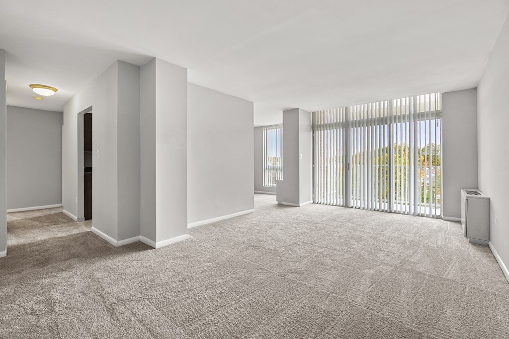 A spacious room with a carpeted floor and white walls.