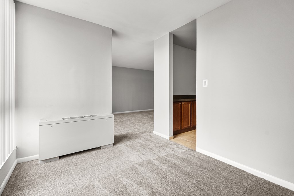 A white filing cabinet sits in a room with a carpeted floor.