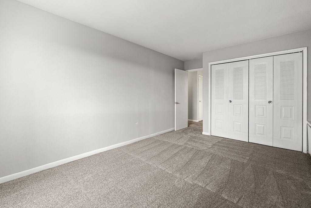 A room with a carpeted floor and a white door.