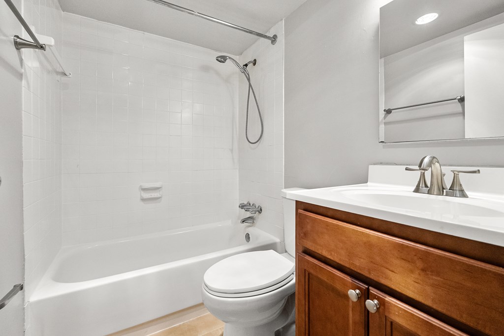 A white bathroom with a toilet, sink, and bathtub.