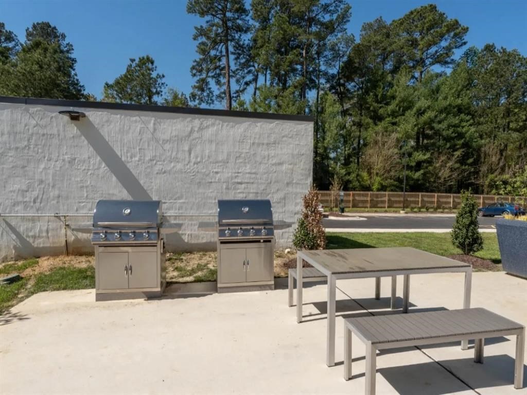 two grills and a picnic table in front of a building at The James On Merrimac, Williamsburg Virginia