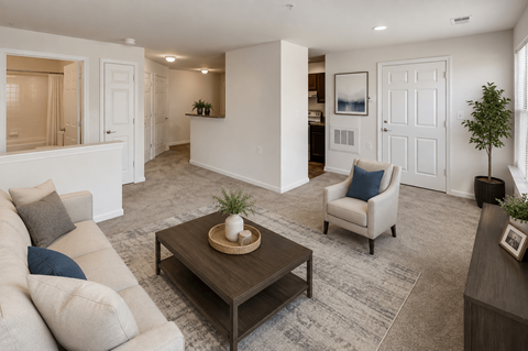 A living room with a beige couch, a coffee table, and a chair.