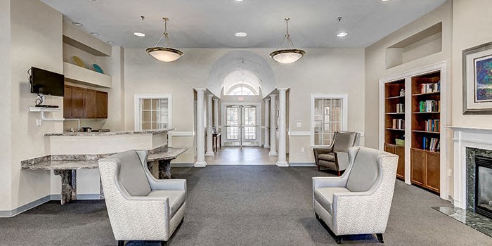 a waiting room with chairs and a table and a window at Windsor Crossing, Suitland 