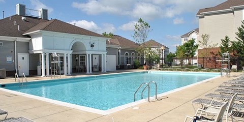 A large swimming pool with a building in the background.