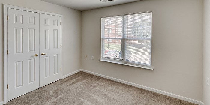 an empty bedroom with a window and a door at Windsor Crossing, Suitland, MD 20746 