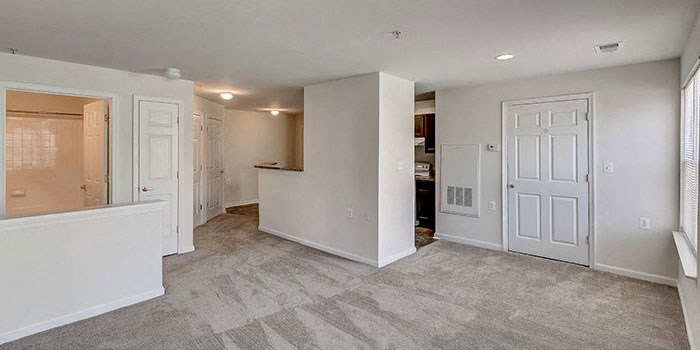 an empty living room and kitchen with white doors at Windsor Crossing, Suitland, MD 20746 