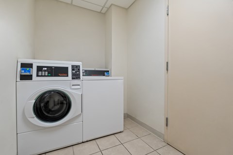A white washing machine and dryer in a small room.