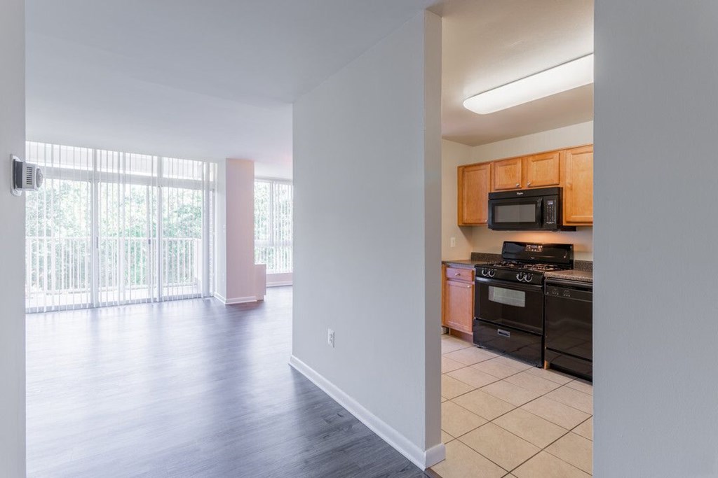 A kitchen with black appliances and wooden cabinets at Charlestowne North Apartments, Greenbelt, MD