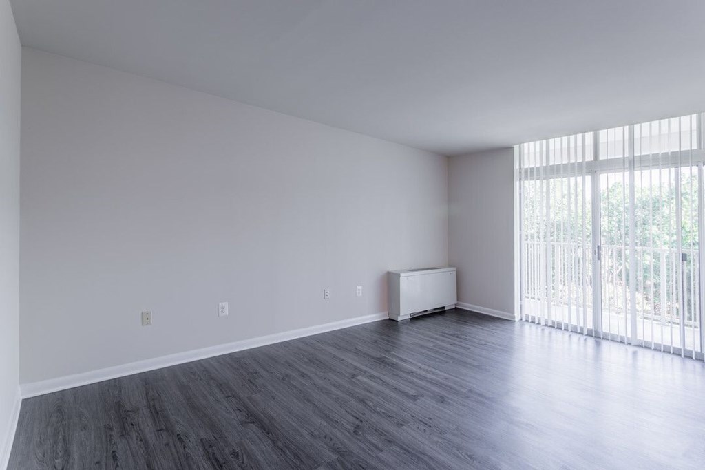 A room with wooden floors and a window with blinds at Charlestowne North Apartments, Greenbelt, MD