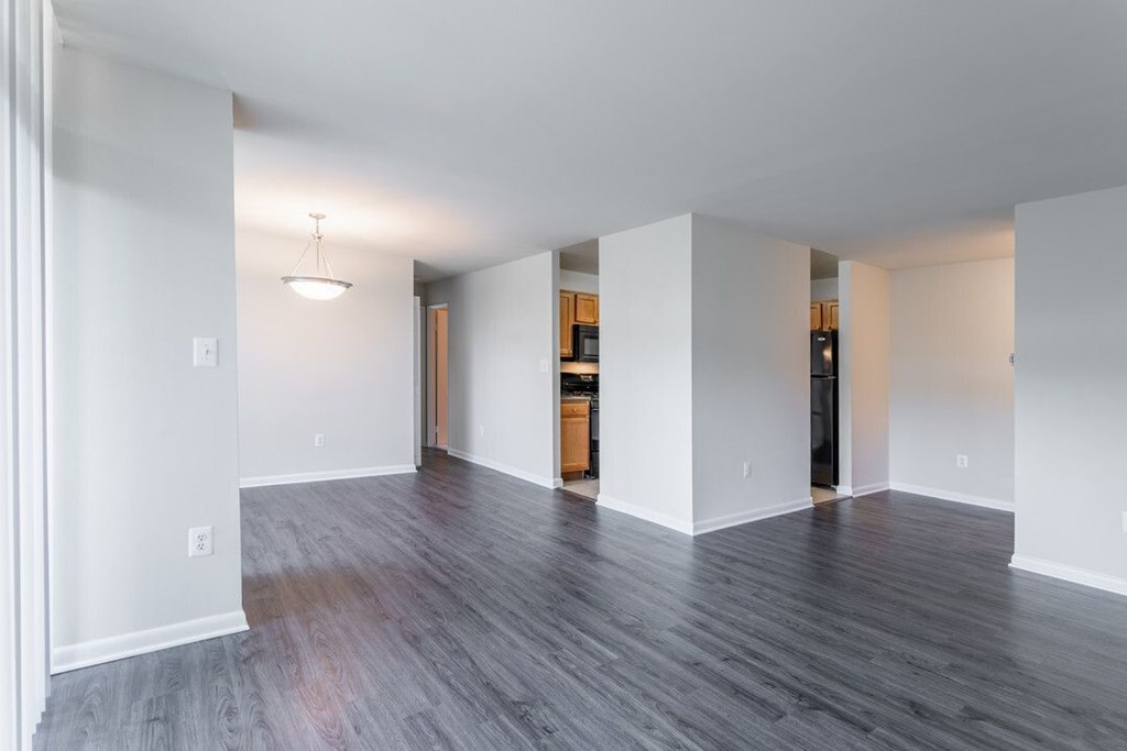 A room with white walls and a wooden floor at Charlestowne North Apartments, Greenbelt, MD, 20770