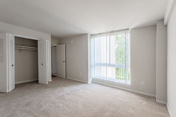 A room with a carpeted floor and a sliding glass door.