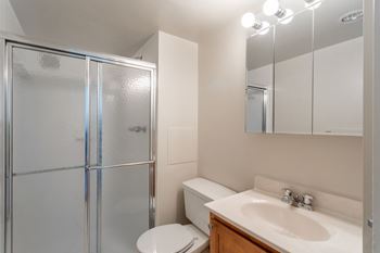 A bathroom with a toilet, sink, and mirror.
