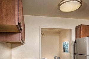 kitchen at Cole Spring Plaza apartments in Silver Spring MD with stainless steel appliances, light tile floors and dark wood cabinets - Photo Gallery 5