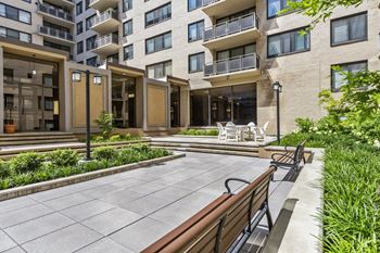 A modern building with a courtyard and benches.