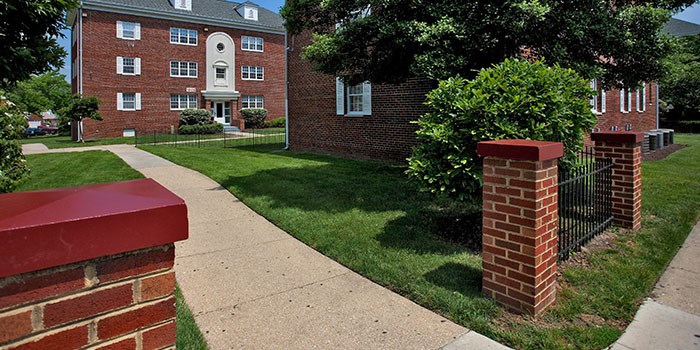 A red brick building with a white door and windows. at University Landing Apartments, Silver Spring, Maryland