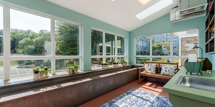 A kitchen with a bench and a window with a view of a parking lot at Rainier Manor Apartments, Mount Rainier, Maryland