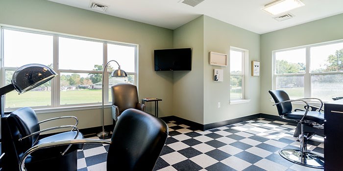 A black and white checkered floor in a room with chairs and a television. at Rainier Manor Apartments, Maryland, 20712