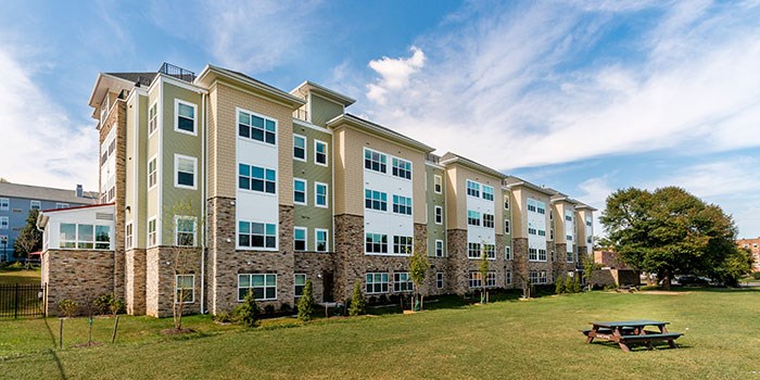 A large building with a grassy field in front of it. at Rainier Manor Apartments, Mount Rainier
