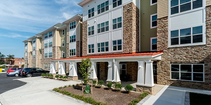 A modern apartment building with a parking lot in front. at Rainier Manor Apartments, Mount Rainier, Maryland