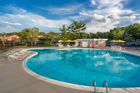 A large outdoor swimming pool with a yellow umbrella at Charlestowne North Apartments, Greenbelt, Maryland