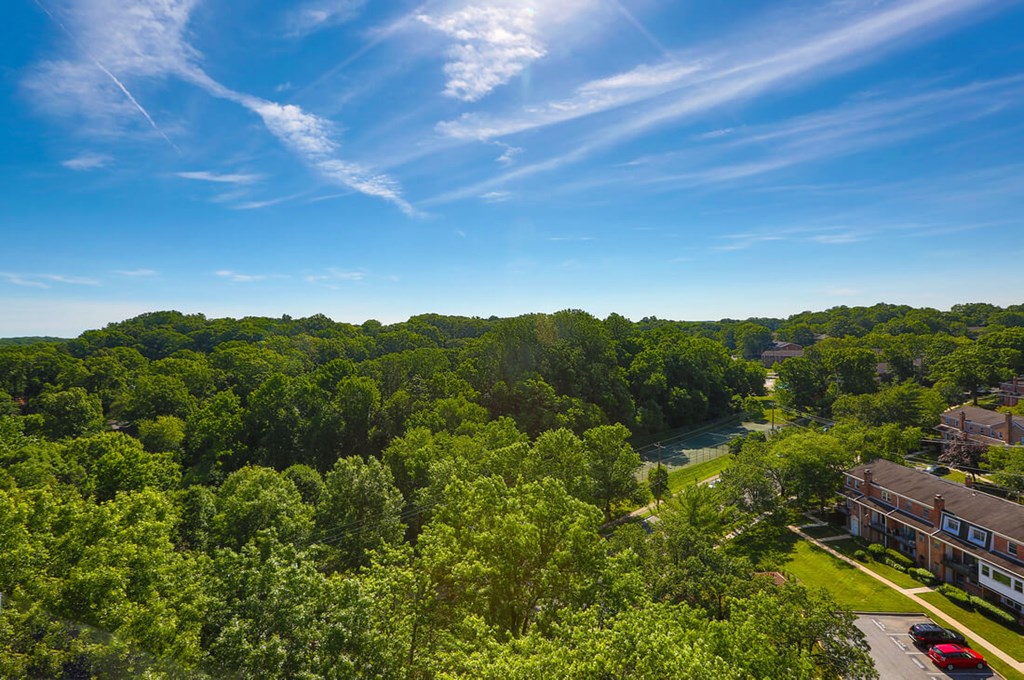 A serene landscape with a building, trees, and a river at Charlestowne North Apartments, Greenbelt