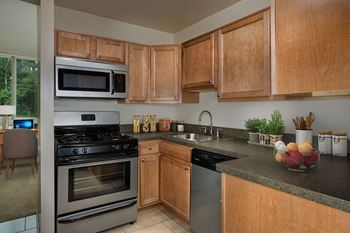 A kitchen with wooden cabinets and a black stove top oven.
