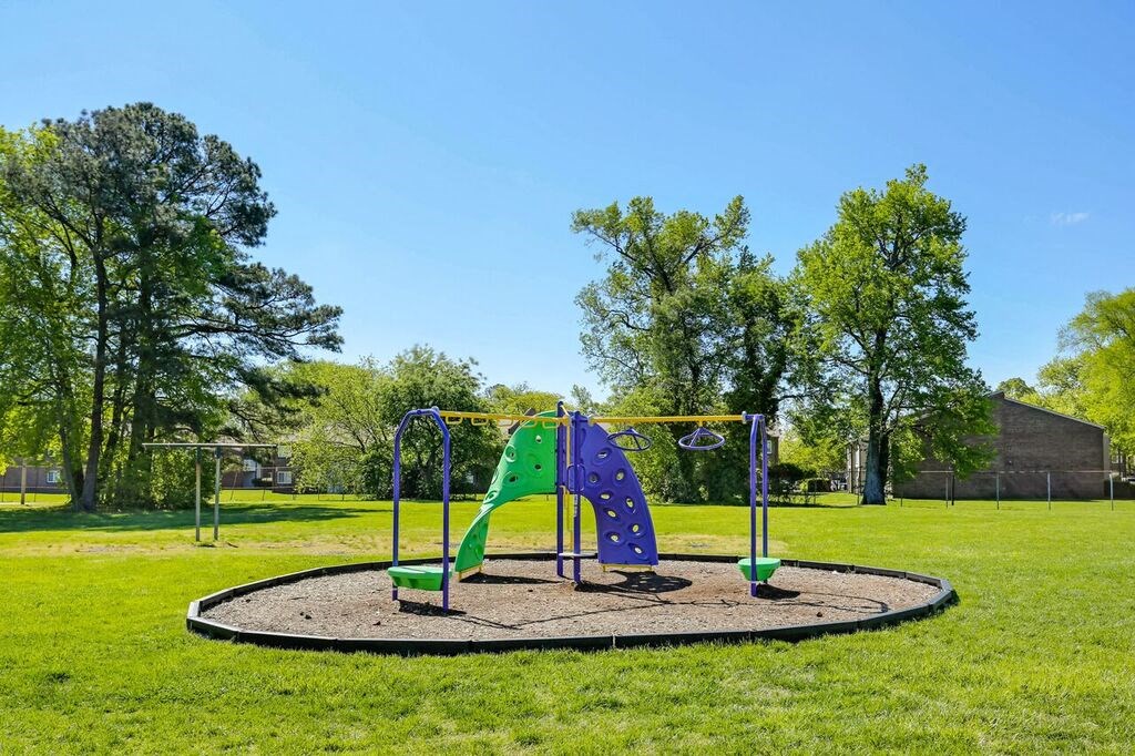 a playground with a swing set in a park
