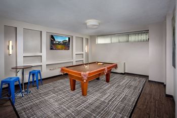 A room with a table, chairs and a television.