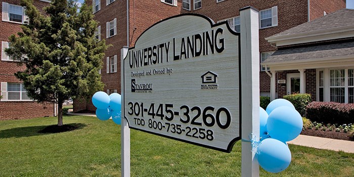 A sign for University Landing is displayed in front of a building. at University Landing Apartments, Silver Spring, MD, 20903