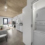 a kitchen and a living room with a white refrigerator