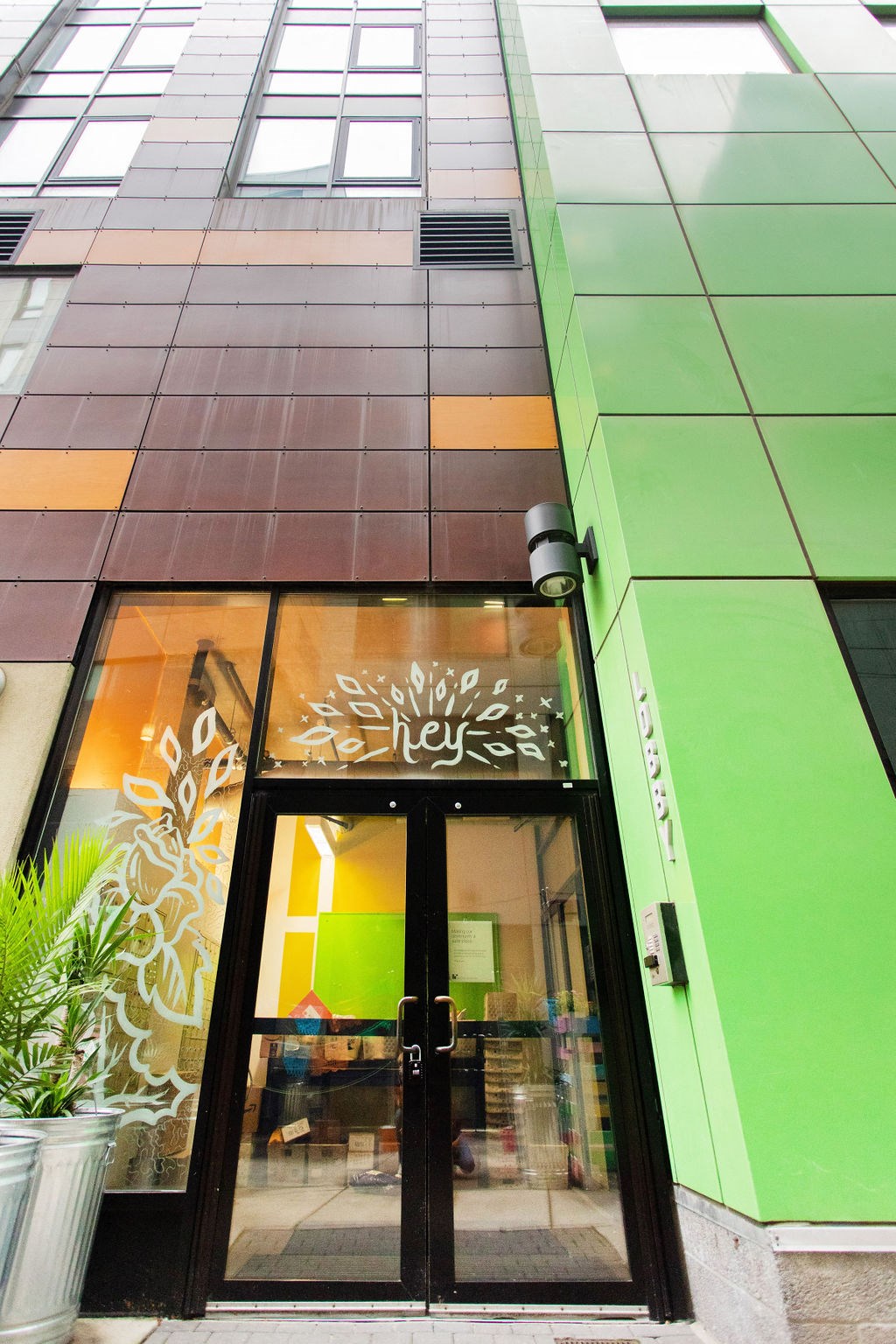 the front of a restaurant with glass doors and a green facade