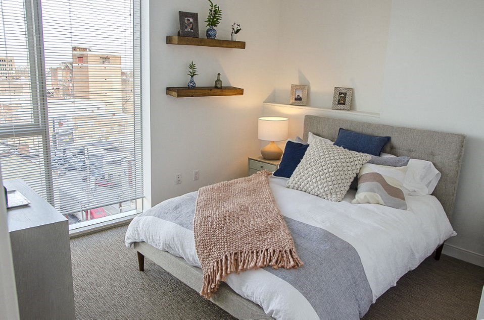 a bedroom with a bed and a large window