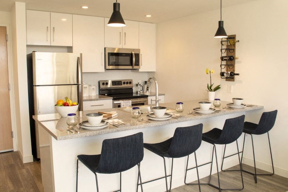 a kitchen with a counter and chairs