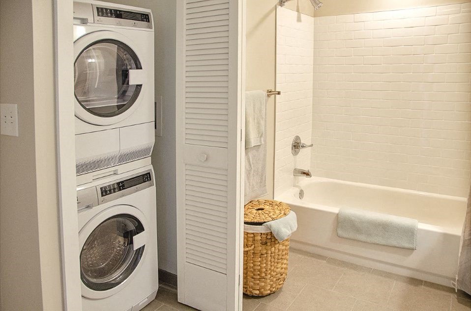 a bathroom with a washing machine and a tub