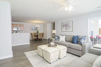 a living room with a couch and an ottoman at Enclave at West Ashley Apartments, Charleston