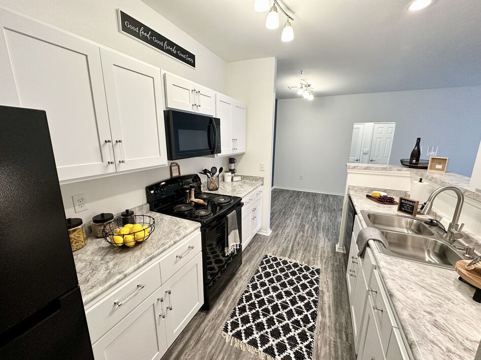A kitchen with black and white checkered floor mat.