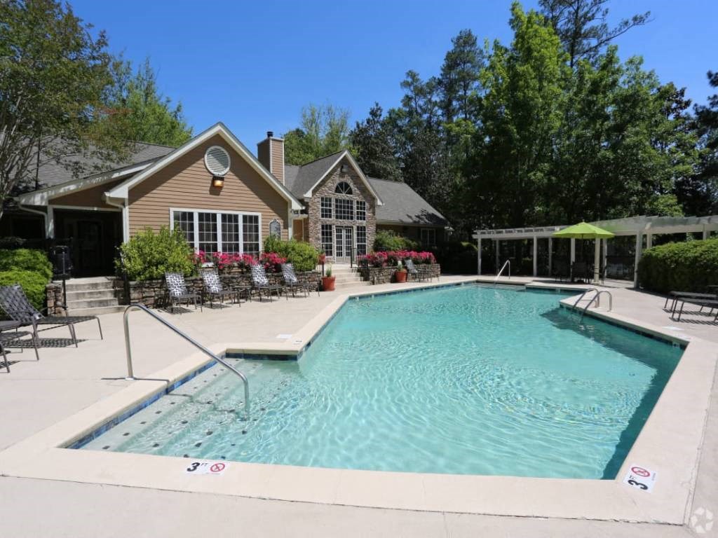 a swimming pool with a house in the background
