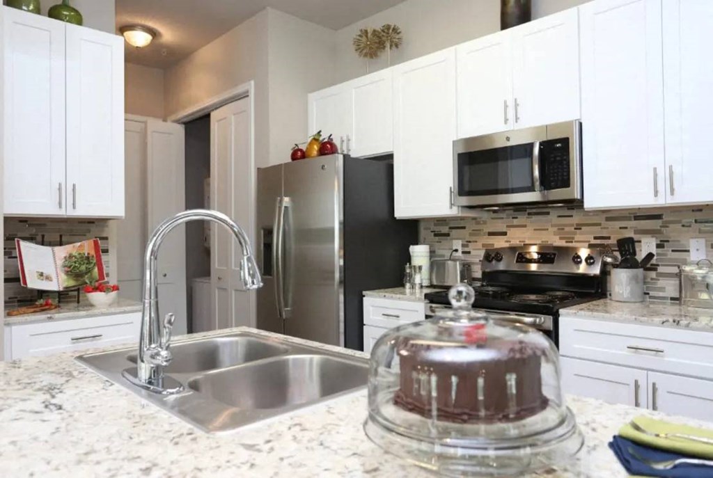 a kitchen with a sink and a stove at Kings Cove, Kingwood, TX