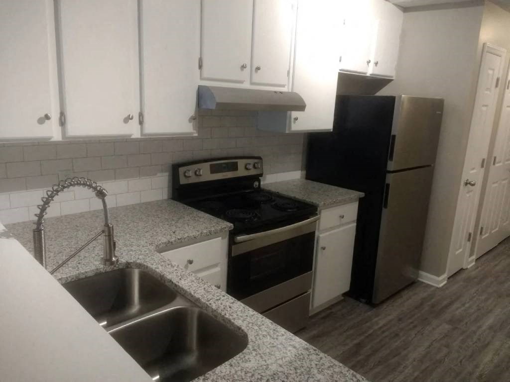 a kitchen with white cabinets and a sink